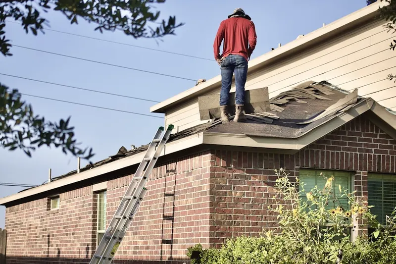 Professional roofer working on a residential roof in Curry